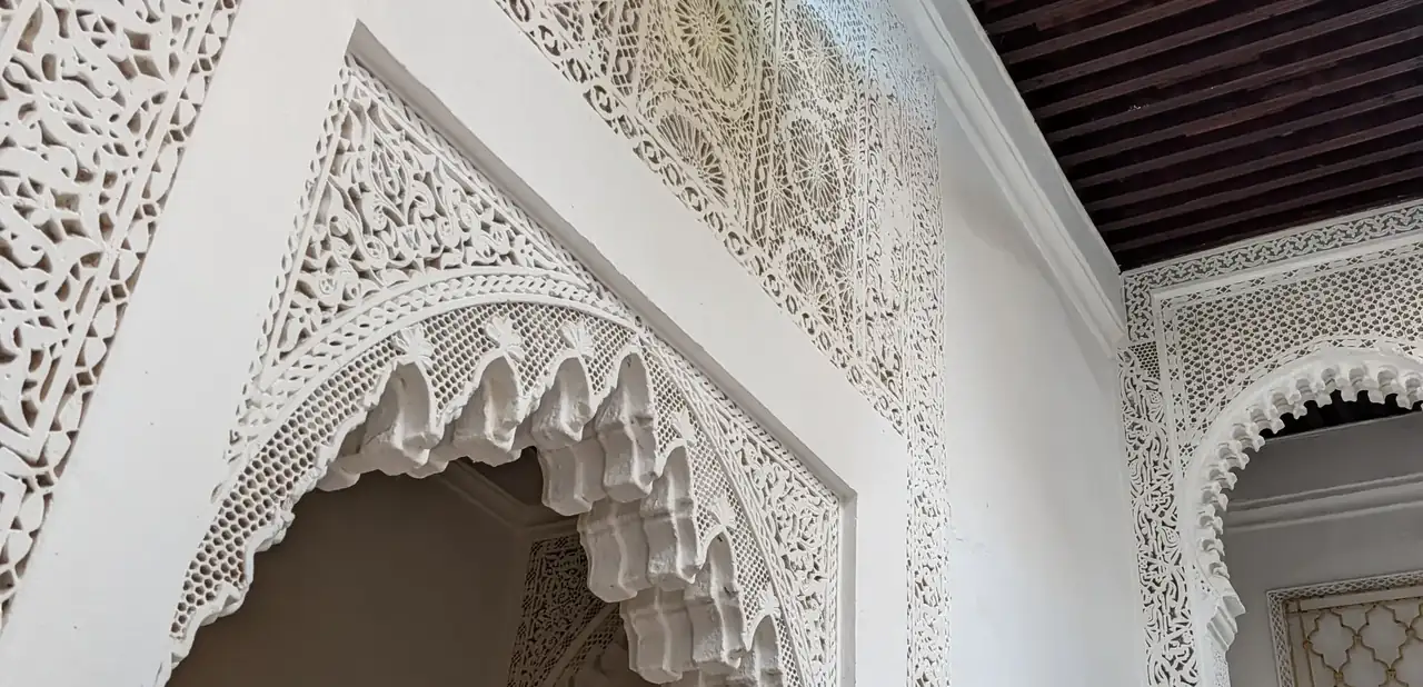 Arc en plâtre sculpté sous un plafond de bois, dans la maison
