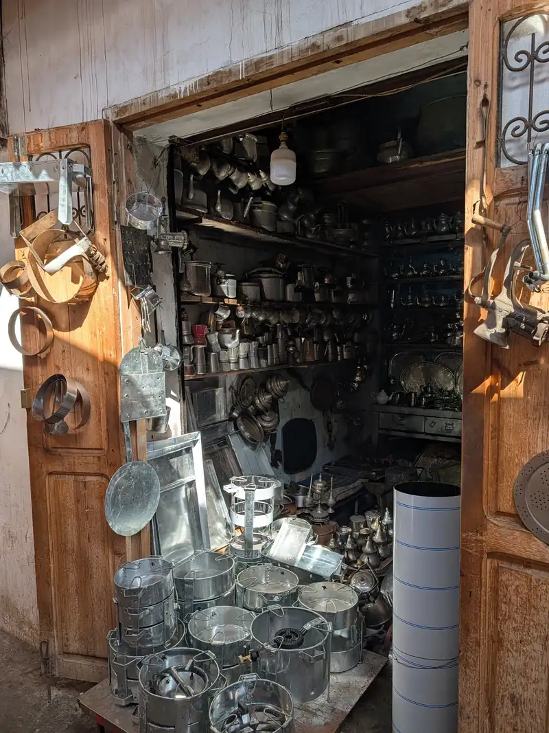 Boutique de ferblantier ouverte sur la rue, ustensiles en fer-blanc et théières