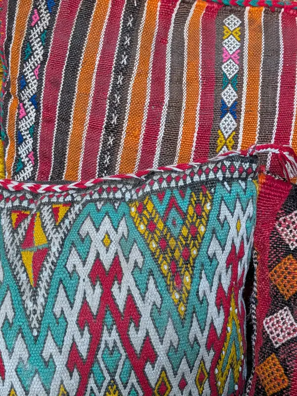 Coussins tissés, rayés et à motifs de losanges, dans le patio-salon