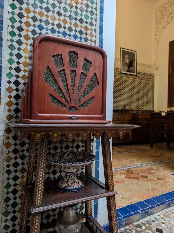 Poste de radio ancien en bois, posé sur un guéridon marqueté, au rez-de-chaussée